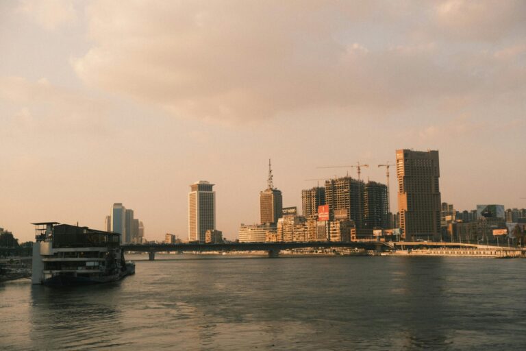 A scenic view of Cairo's skyline along the Nile River at sunset, capturing the city's modern architecture.