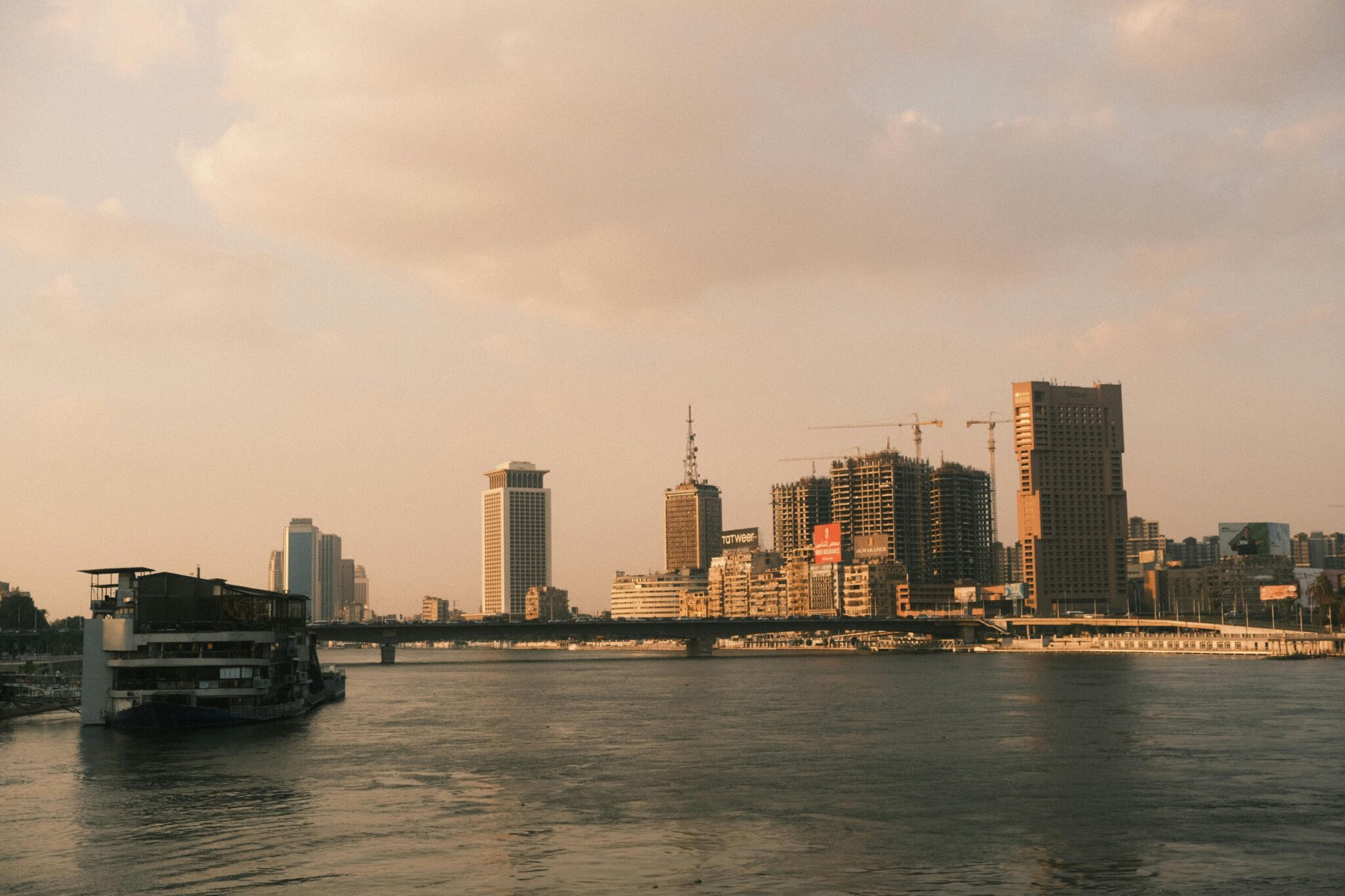 A scenic view of Cairo's skyline along the Nile River at sunset, capturing the city's modern architecture.